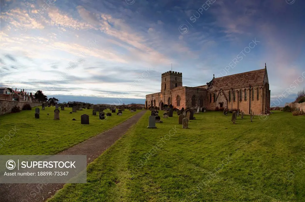 Path leading to a church building and cemetery, bamburgh northumberland england