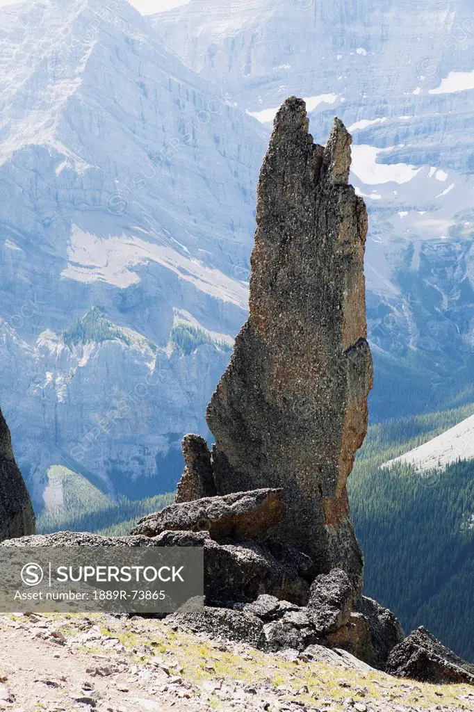 Large Rock Sentinel On Mountain Ridge With A Mountain Range In The Distance, Alberta Canada