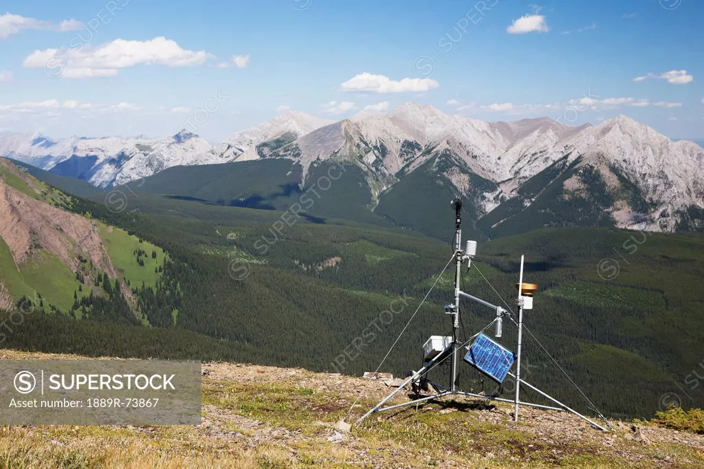A Weather Station On Top Of A Ridge With Mountains And Valley In The Distance And Blue Sky With Clouds, Alberta Canada