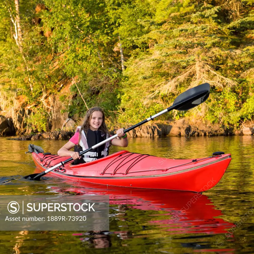 A girl kayaking in the lake, lake of the woods ontario canada
