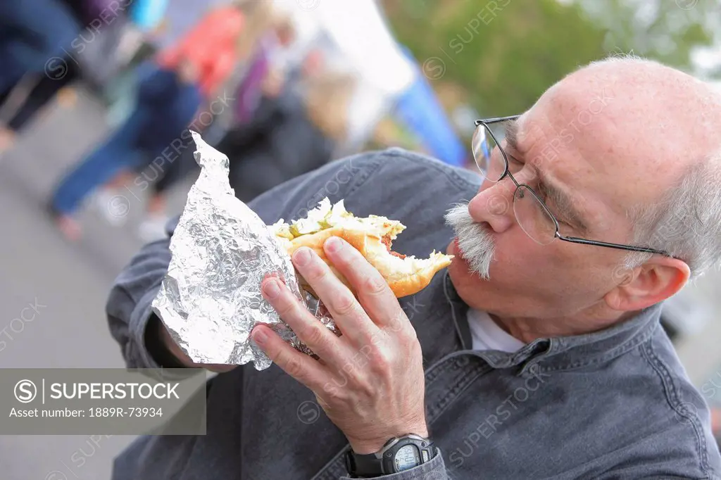 Senior man eating a hot dog, troutdale oregon united states of america