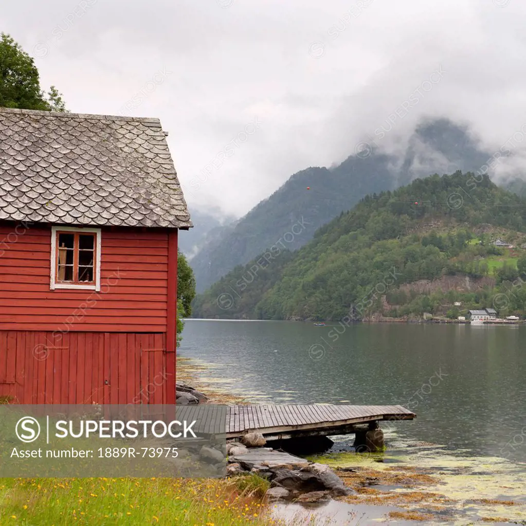 A red building and dock along hardangerfjord, hardangervidda norway