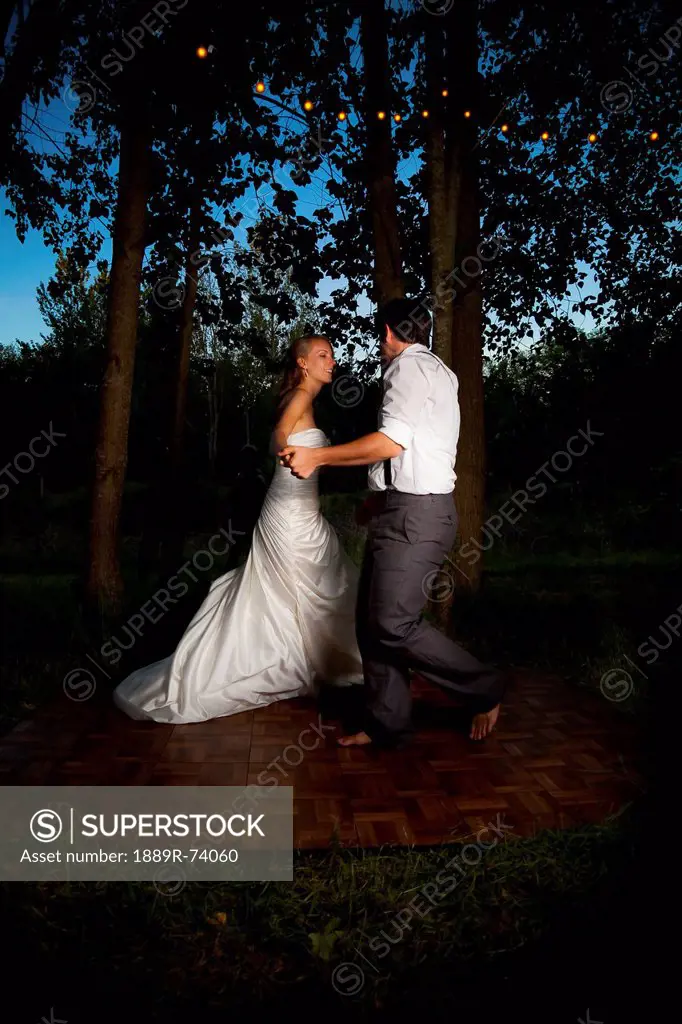 Bride and groom dancing at dusk on an illuminated dance floor, vancouver british columbia canada