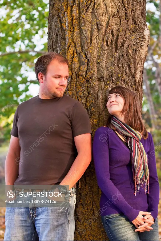 Young Married Couple Leaning Against A Tree In A Park In Autumn, Edmonton Alberta Canada