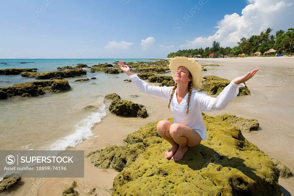 A Woman Tourist Raises Her Arms On The Beach Of A Tropical Island, Koh Lanta Thailand