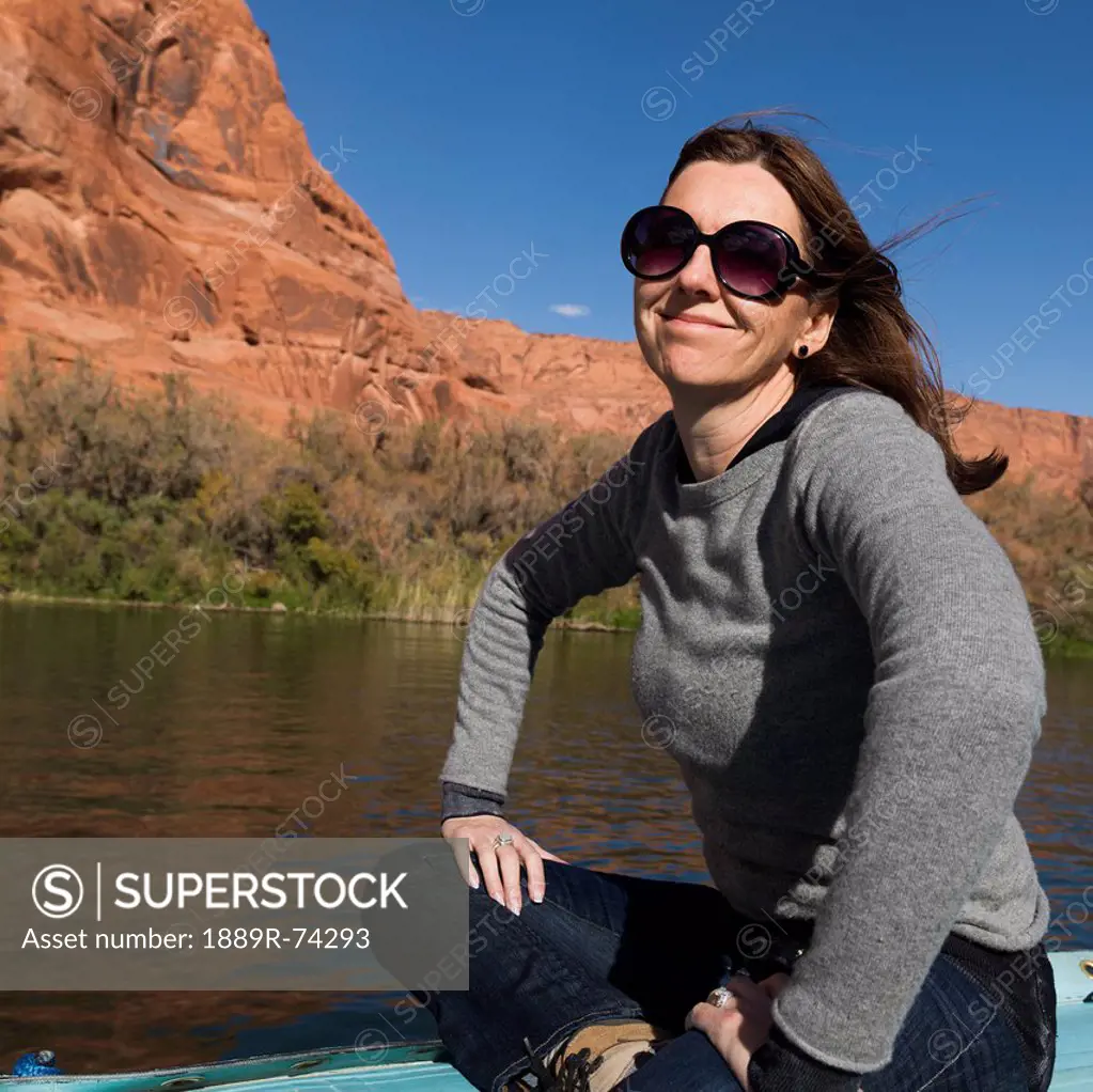 A Woman Sits On A Boat On The Colorado River, Arizona United States Of America