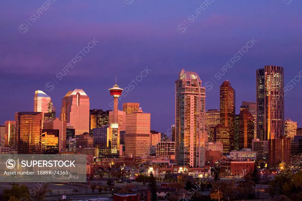 Calgary Skyline At Dawn With City Lights And Deep Blue Sky With Buildings Reflecting The Orange Glow Of Sunrise, Calgary Alberta Canada