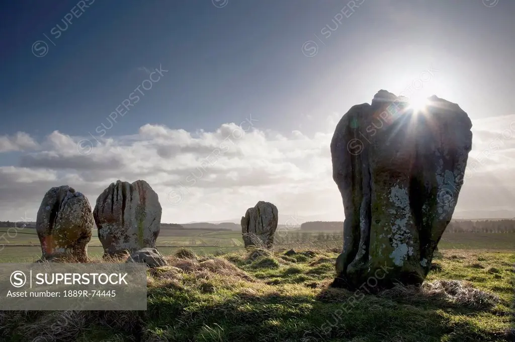 Sunlight shining on the standing stones of duddo, northumberland england