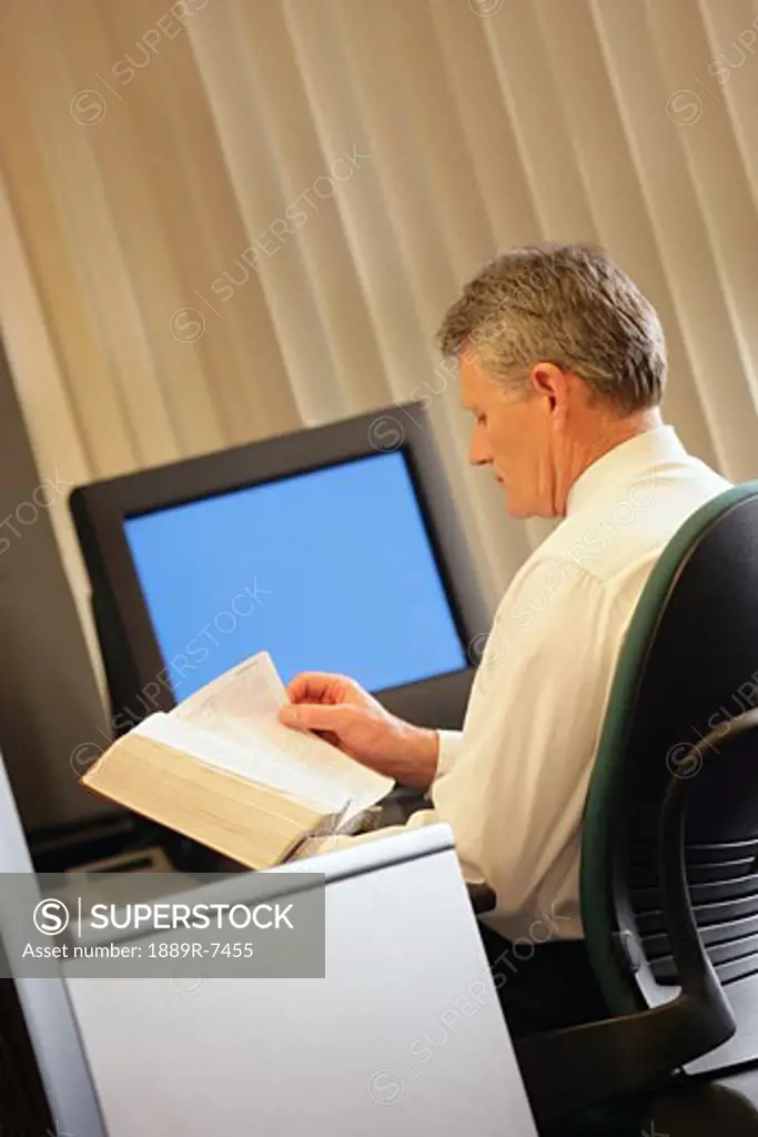 Man reading book in his office