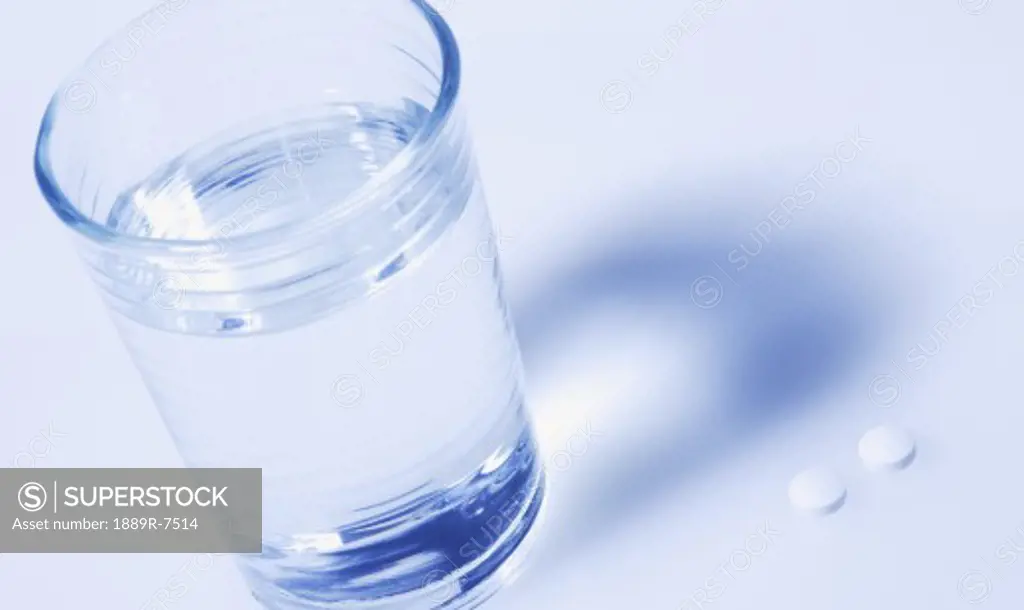 A cup of water with pills