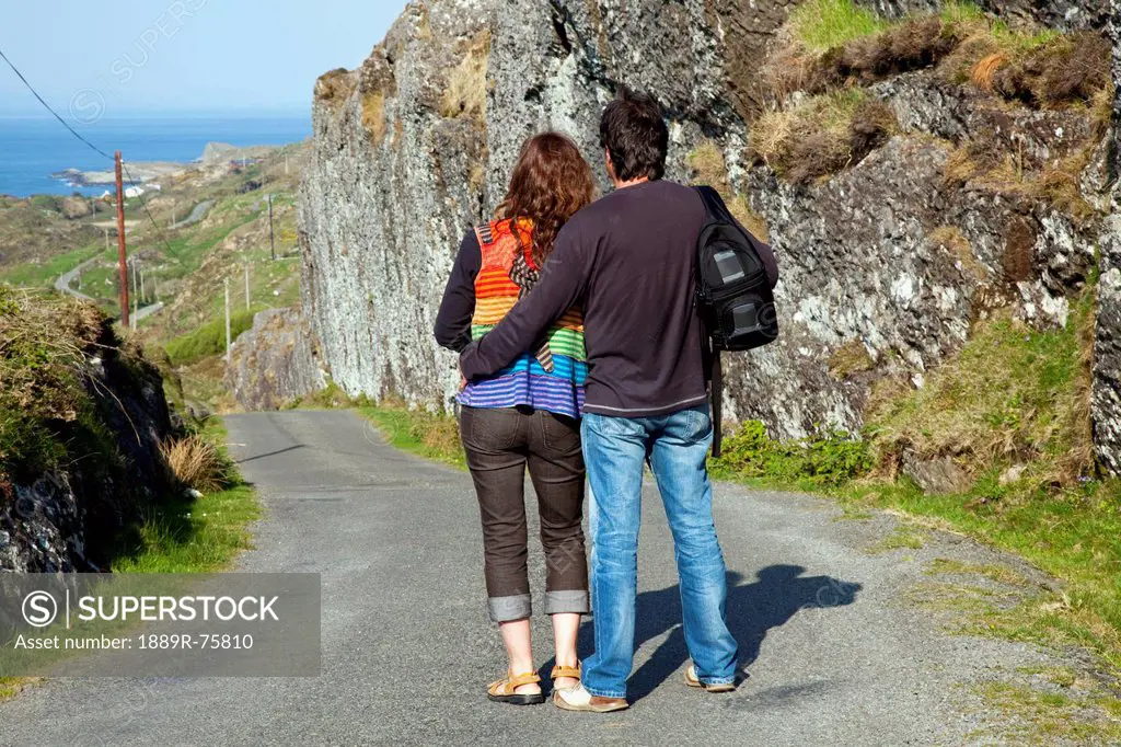 A Man And Woman Stand Looking At The View Of The Ocean Near Argroom, County Cork Ireland