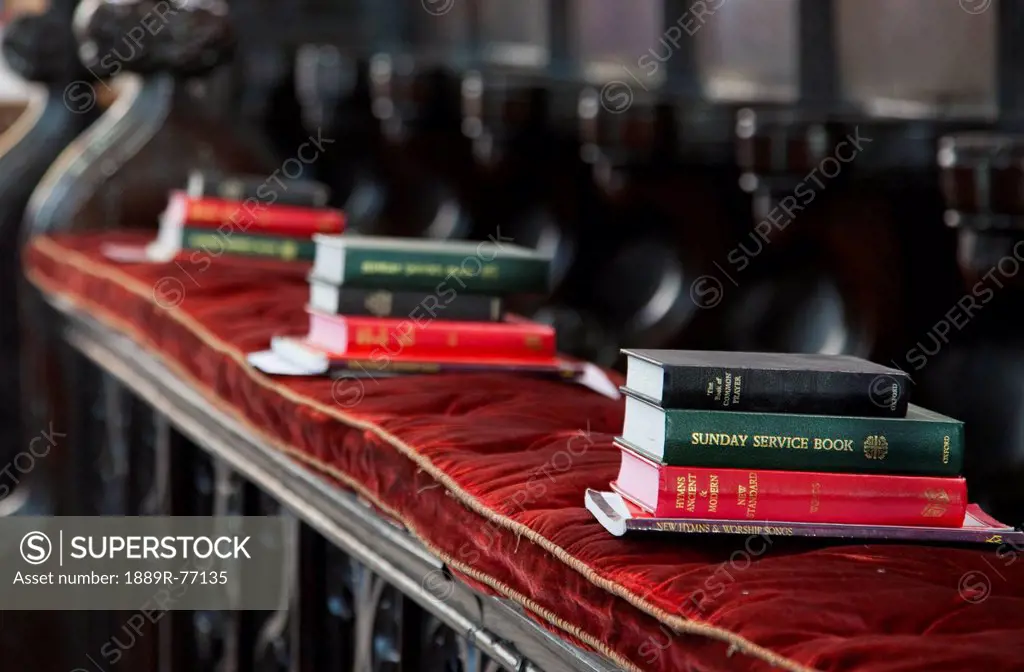 Piles of hymn and service books on a bench in a church, staindrop durham england