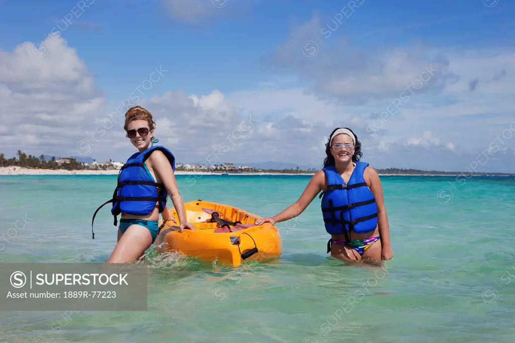 Two women in lifejackets with a yellow boat, punta cana la altagracia dominican republic