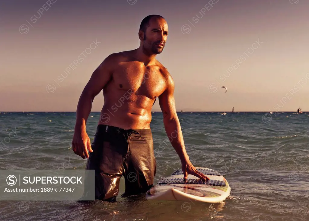 A Man With His Surfboard In The Water At Sunset, Tarifa Cadiz Andalusia Spain