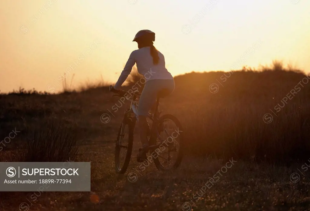 A cyclist rides on a path at sunset, tarifa cadiz andalusia spain