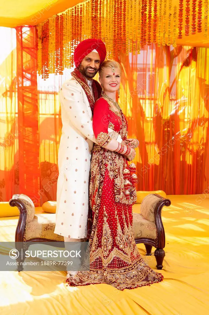 Portrait of a mixed race couple on their wedding day in traditional indian garments for a wedding, ludhiana punjab india
