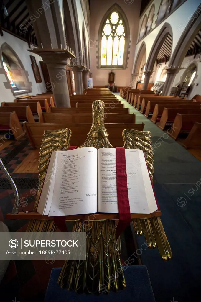 An open bible on a gold podium in st. andrew´s church, kelso scottish borders scotland