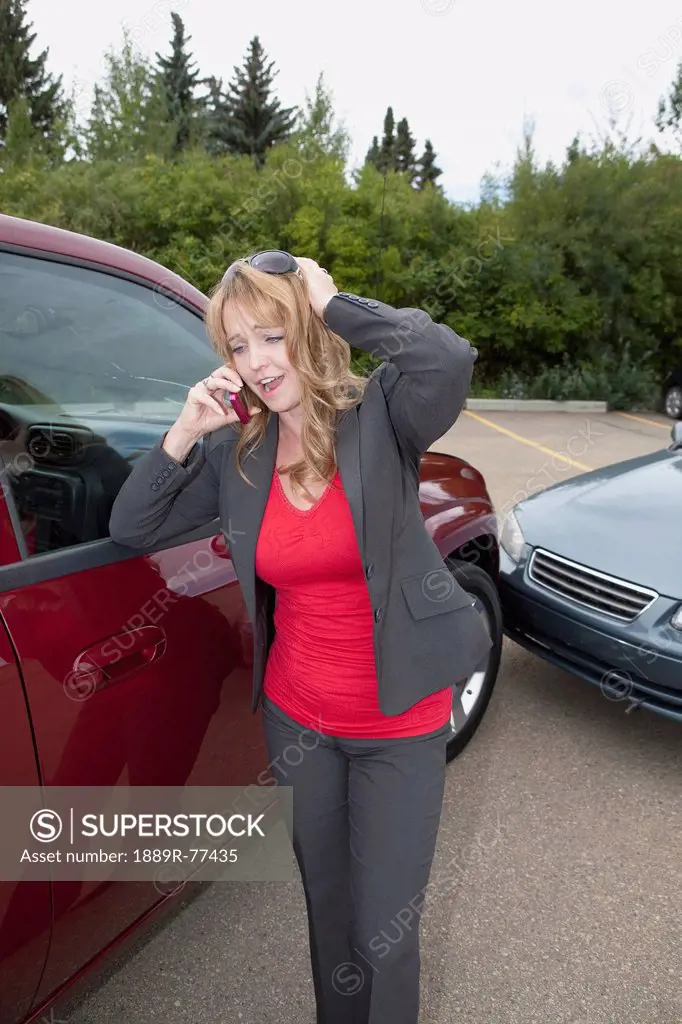a woman makes a phone call for help after she gets into a car accident, edmonton, alberta, canada
