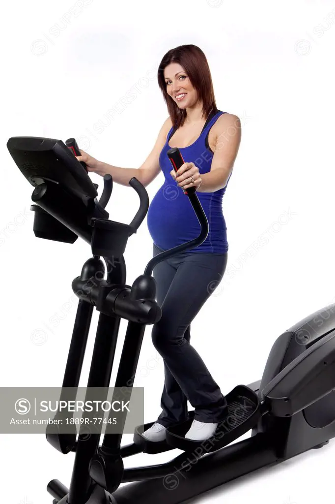 A pregnant woman using fitness equipment, edmonton alberta canada