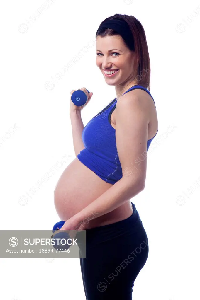 A pregnant woman uses dumbbells for fitness, edmonton alberta canada