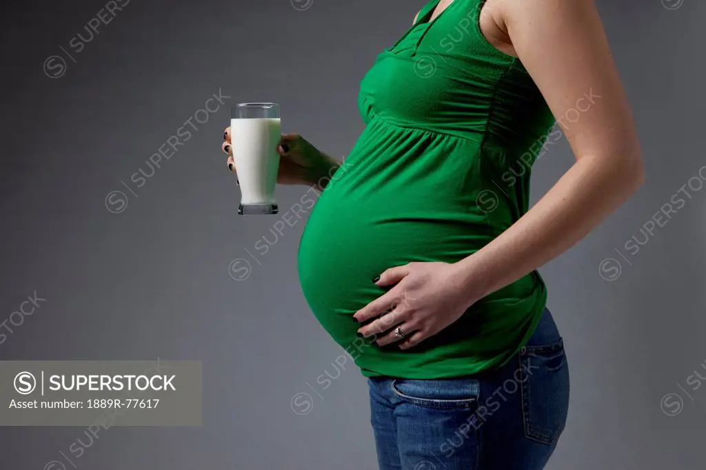 A pregnant woman holding a glass of milk, edmonton alberta canada