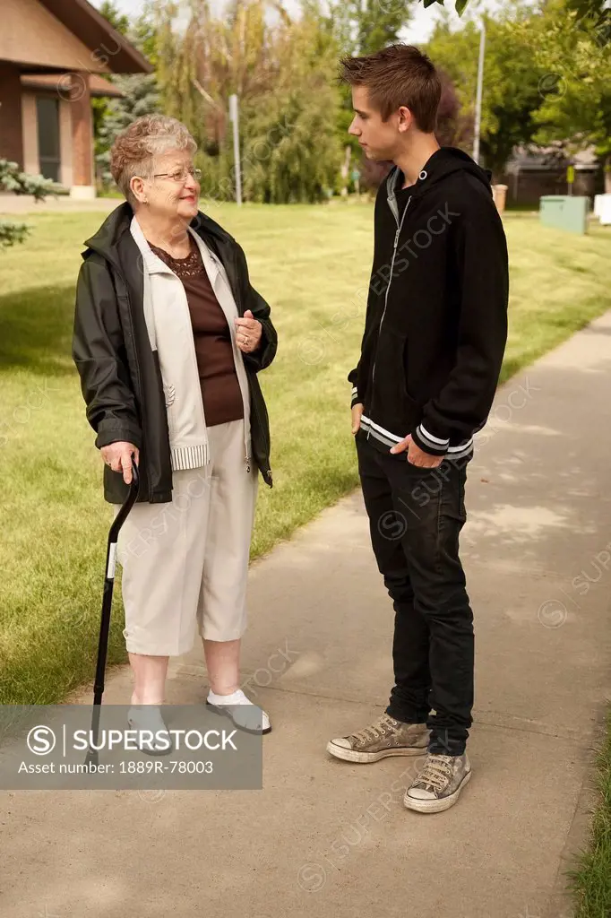 a senior woman talking with a teenage boy, edmonton, alberta, canada