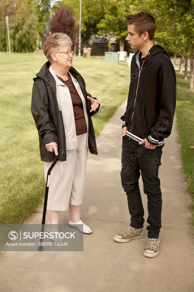 a senior woman talking with a teenage boy, edmonton, alberta, canada