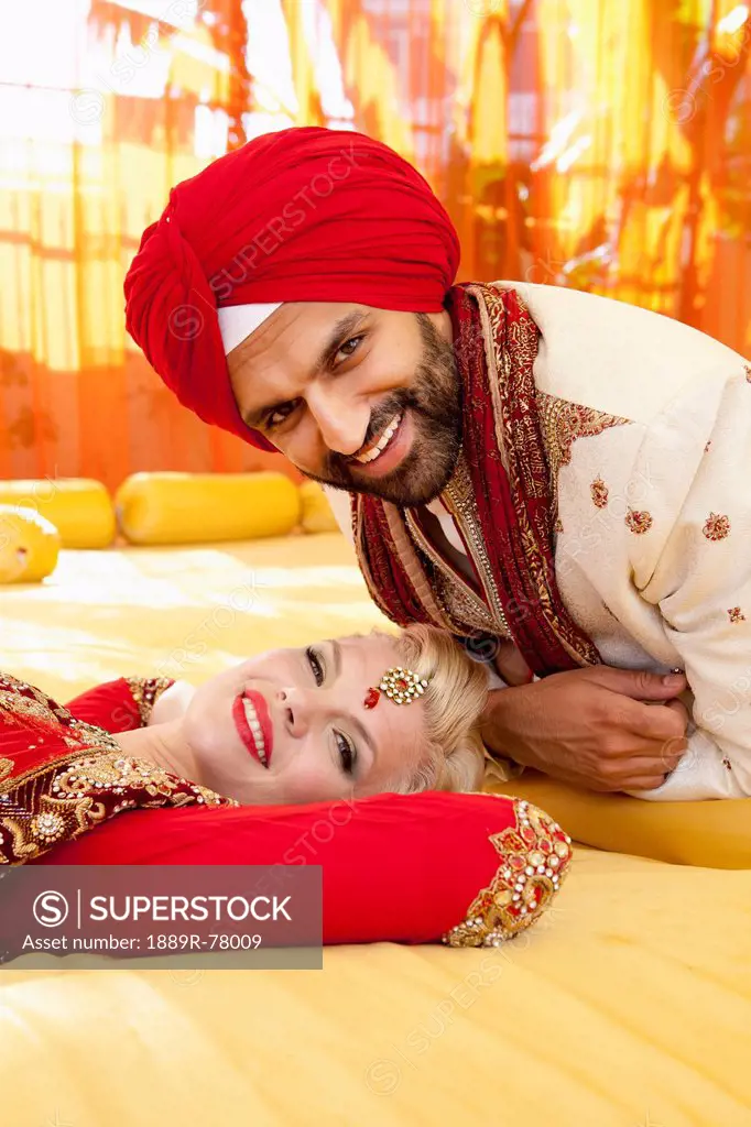 Portrait of a mixed race couple on their wedding day in traditional indian garments for a wedding, ludhiana punjab india