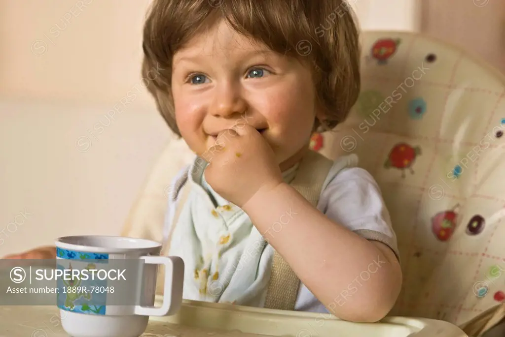 A Young Child Eats A Snack In A Highchair, Thomastown County Kilkenny Ireland
