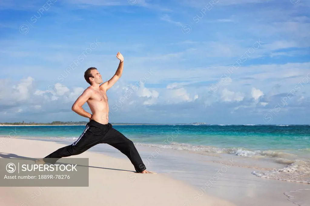A man doing yoga on the beach, punta cana la altagracia dominican republic