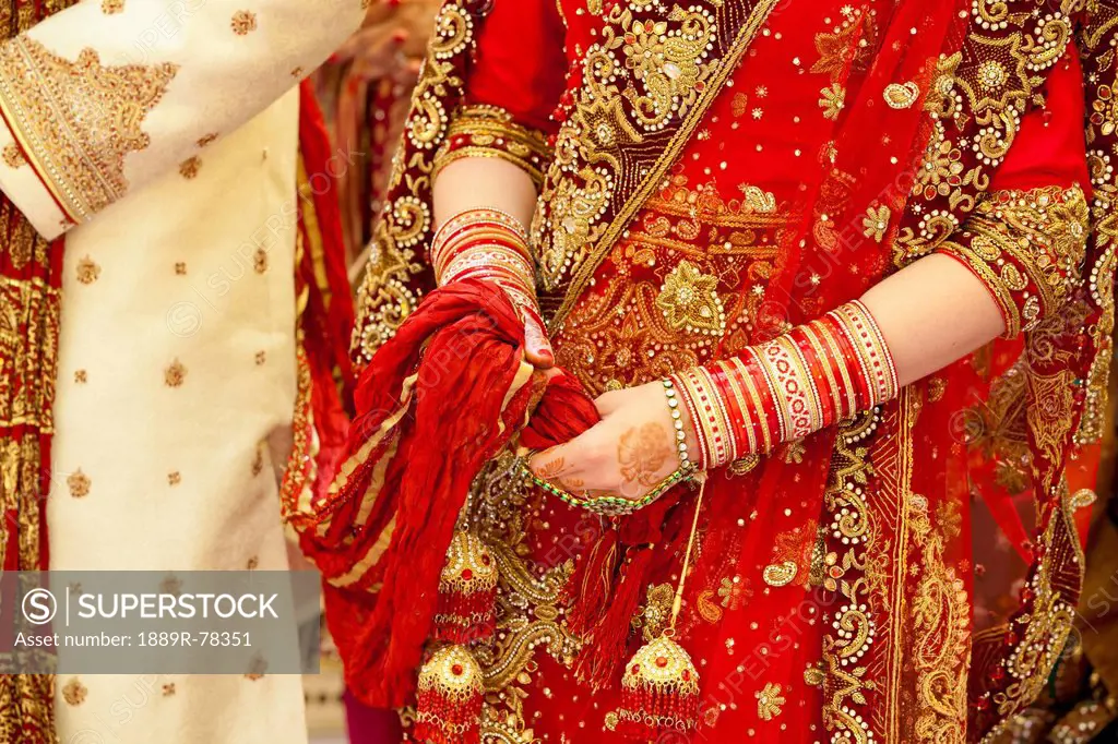 Ornate robes and jewelry worn by the bride and groom on a wedding day in india, ludhiana punjab india