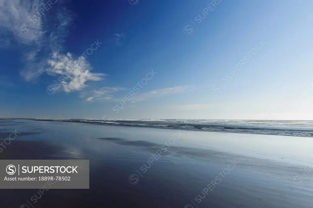 Sunlight reflected on the wet sand of nye beach, newport oregon united states of america