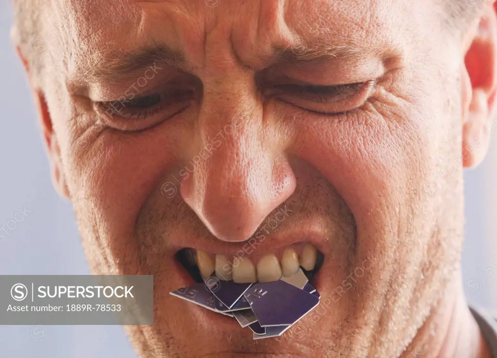 Angry Disappointed Man With Cut_Up Credit Card In Mouth, Torremolinos Malaga Andalusia Spain