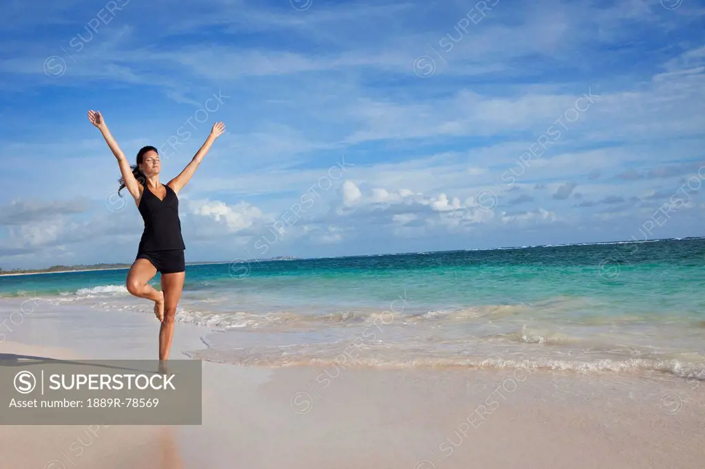 A woman in a yoga pose on the beach, punta cana la altagracia dominican republic