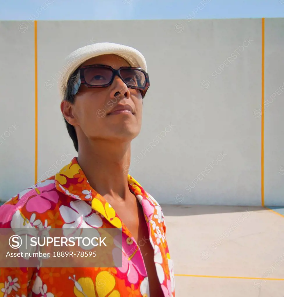 A man in a brightly coloured floral shirt in front of a wall, puerto rico
