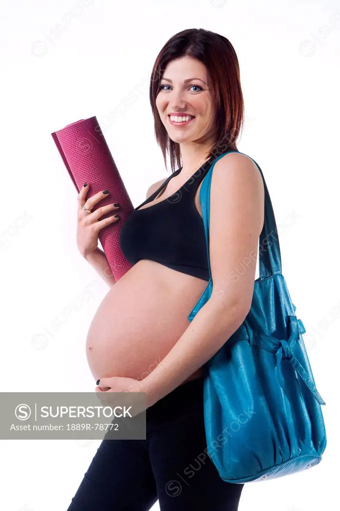 A pregnant woman holding her workout mat and purse, edmonton alberta canada