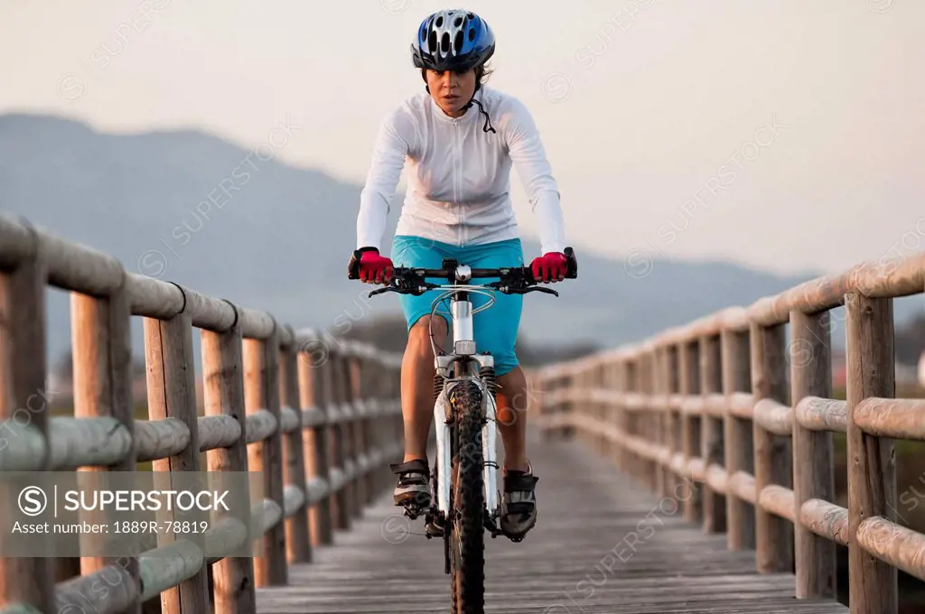 A cyclist rides on a wooden boardwalk, tarifa cadiz andalusia spain