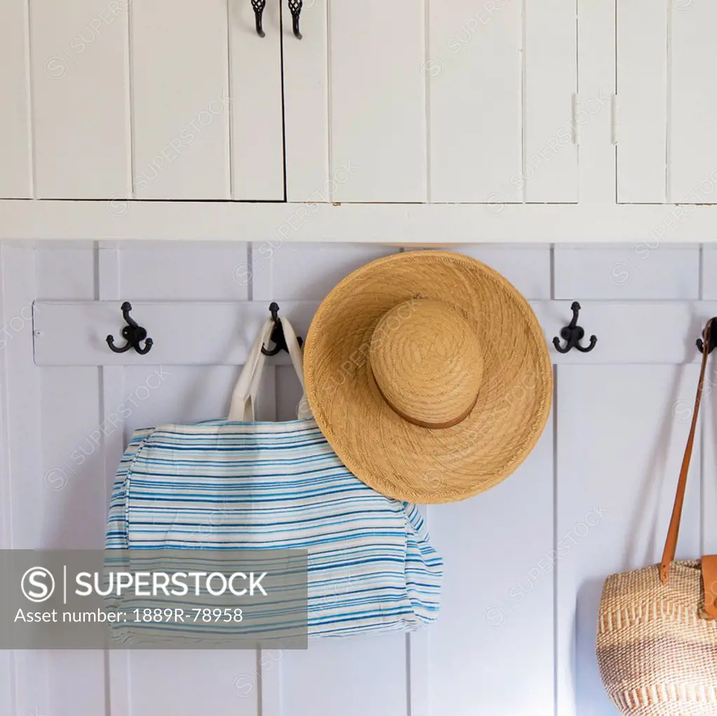 A straw hat and bags hanging on hooks, pigeon lake alberta canada