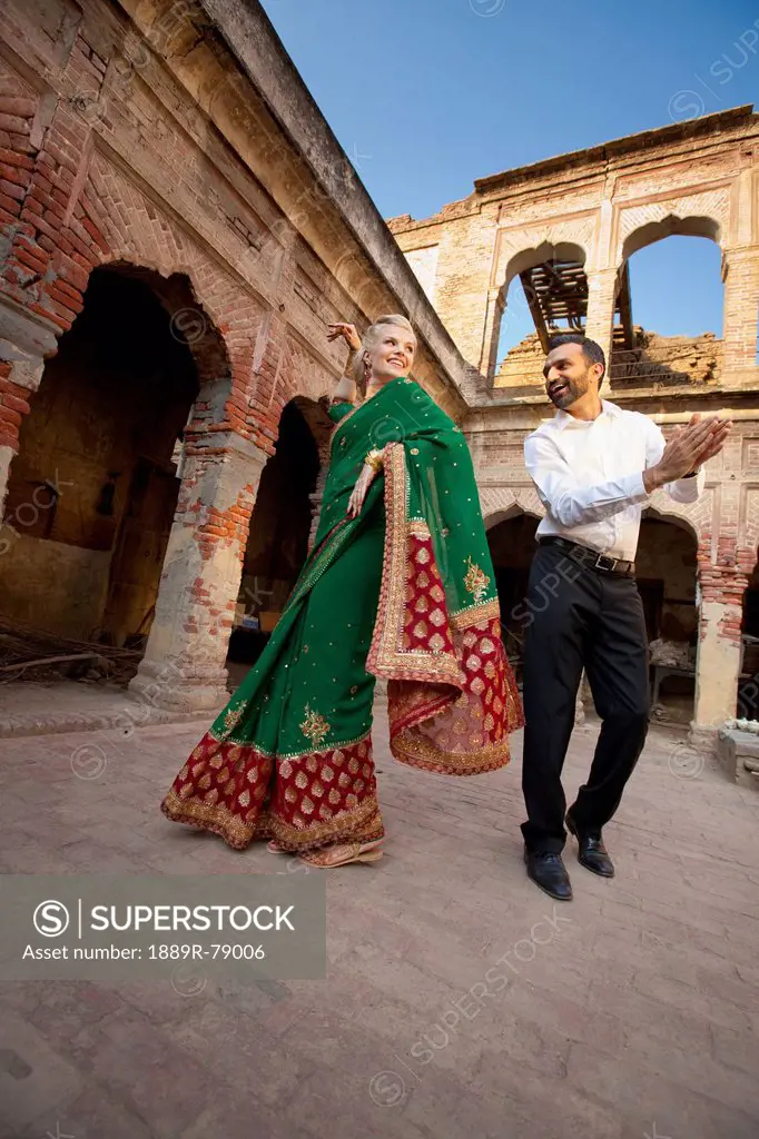 A mixed race couple dancing with her wearing a sari, ludhiana punjab india