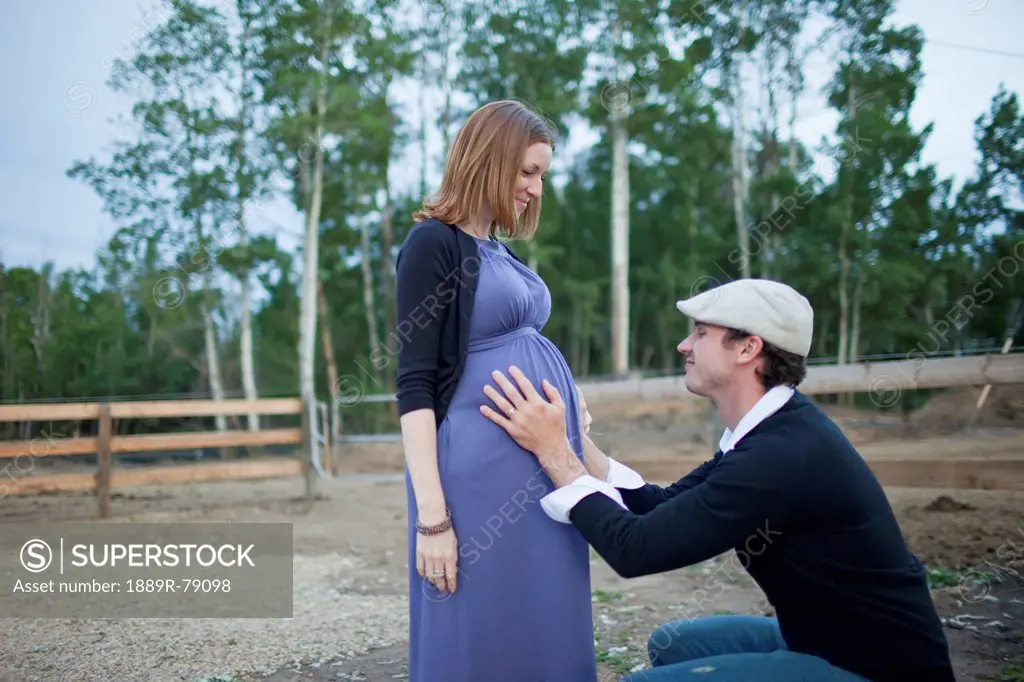 A husband putting his hands on his wife´s pregnant belly, sherwood park alberta canada