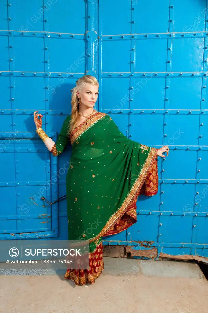 Portrait of a blond woman wearing a sari in front of blue doors, ludhiana punjab india