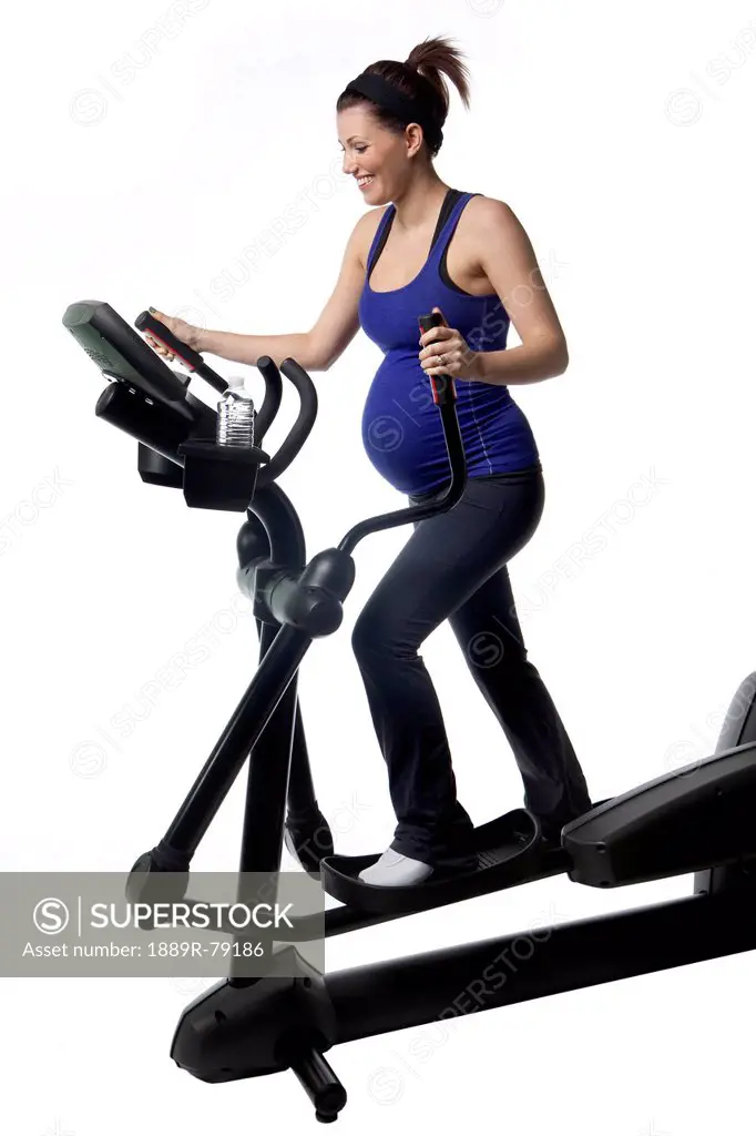 A pregnant woman using fitness equipment, edmonton alberta canada