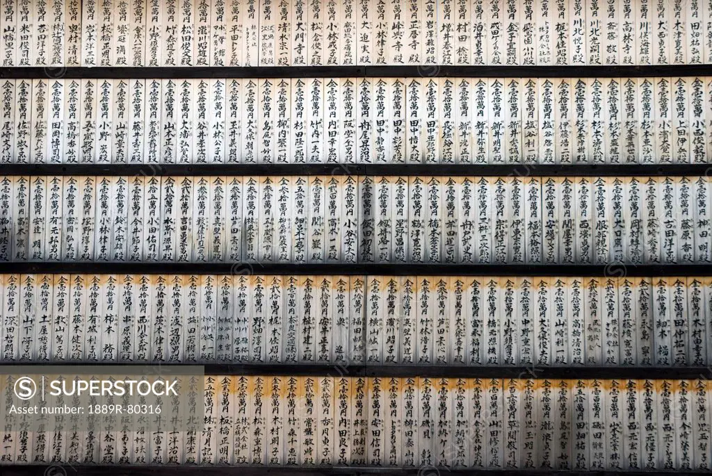 Wall of wooden prayer tablets at a japanese temple, kyoto, japan