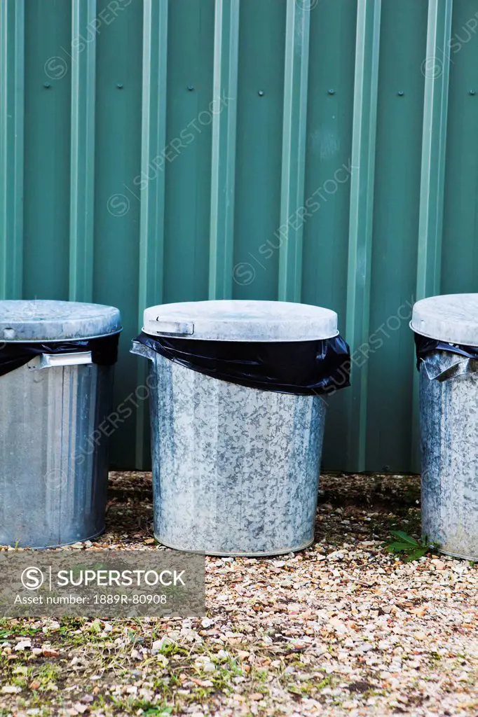 Metal garbage bins in a row against a metal wall, murwillumba new south wales australia