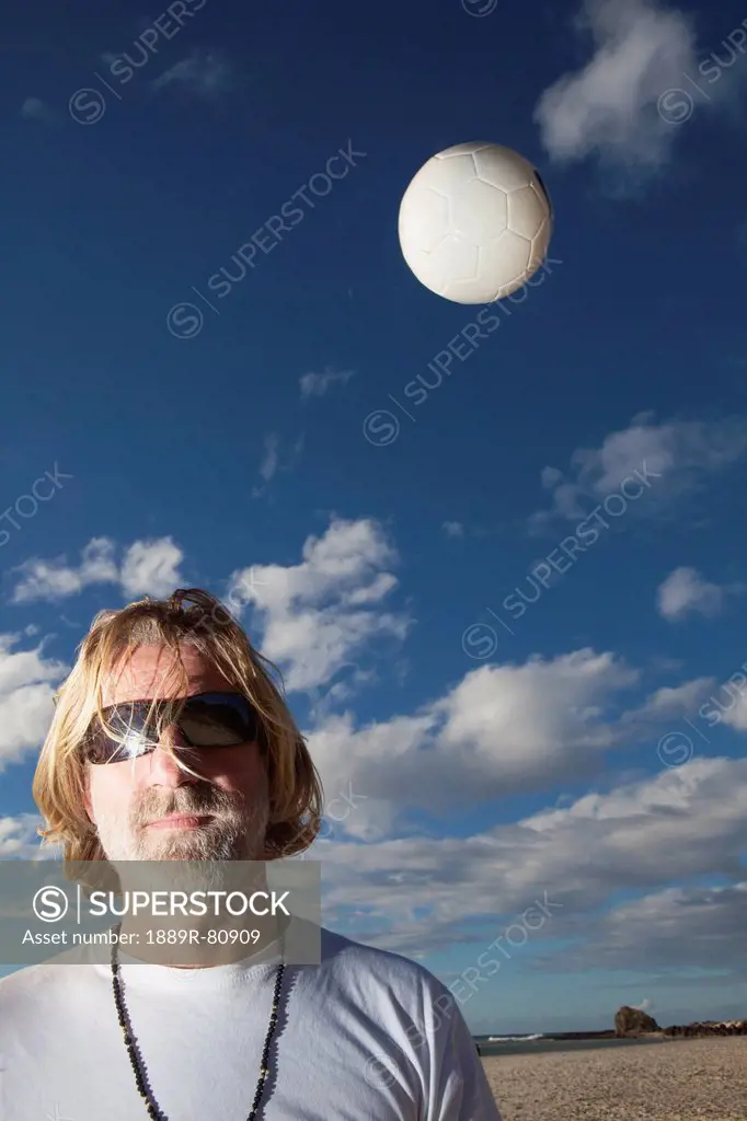 A man with sunglasses and a volleyball in the air, gold coast queensland australia