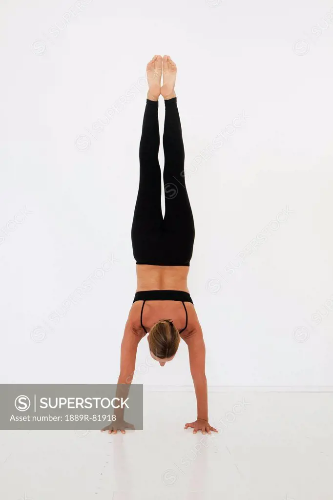 A woman doing a handstand on a white background, tarifa, cadiz, andalusia, spain