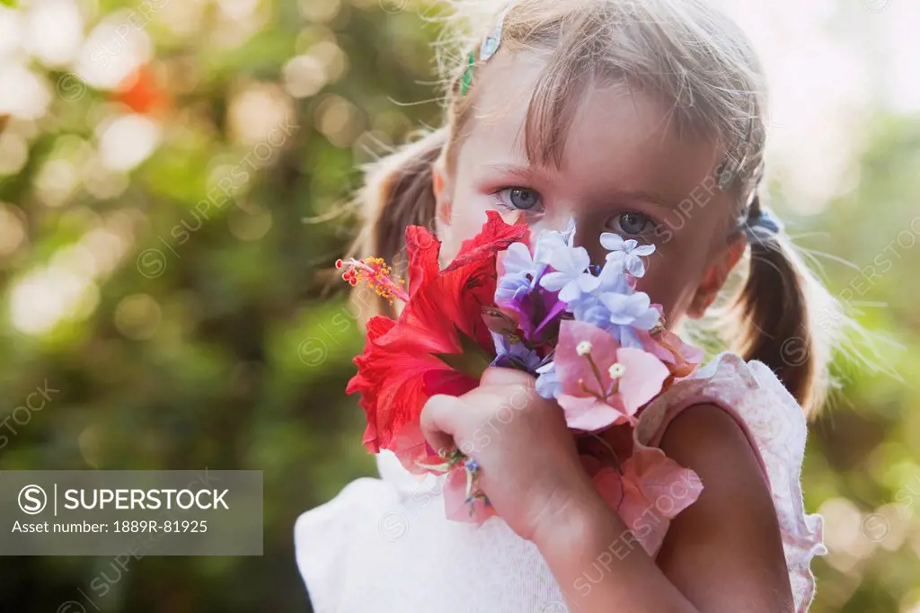 A young girl smelling a colourful bouquet of flowers, torremolinos, malaga, spain