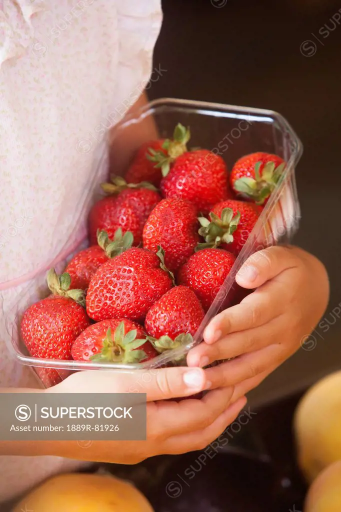 A girl holding a basket of strawberries, torremolinos, malaga, spain