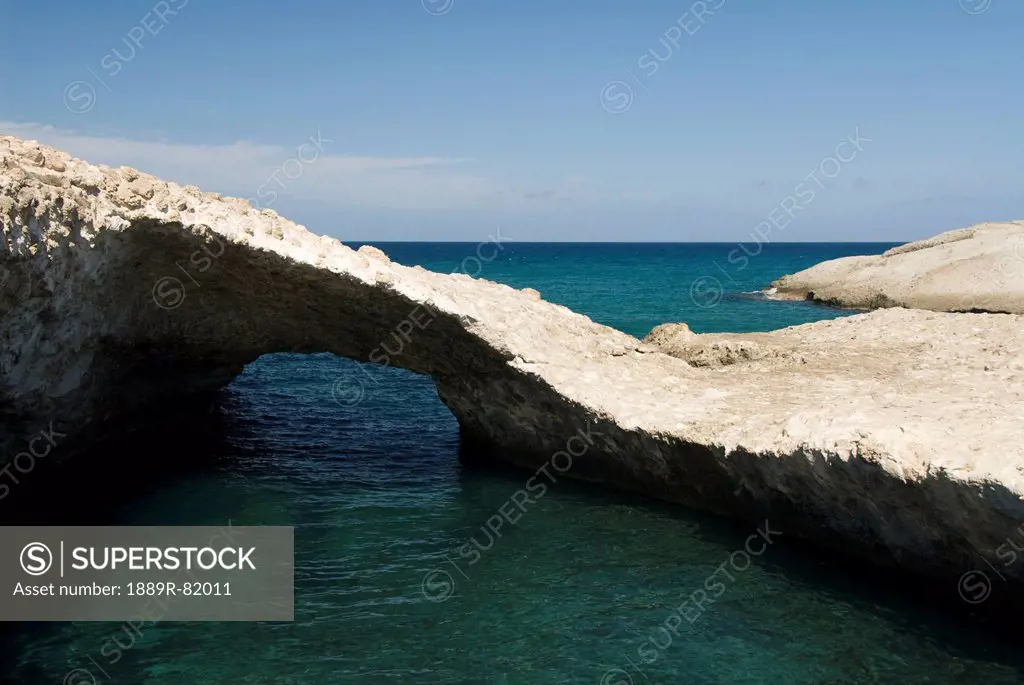 A tranquil pool of water and unique rock formation off the coast, karpos, island of milos, greece