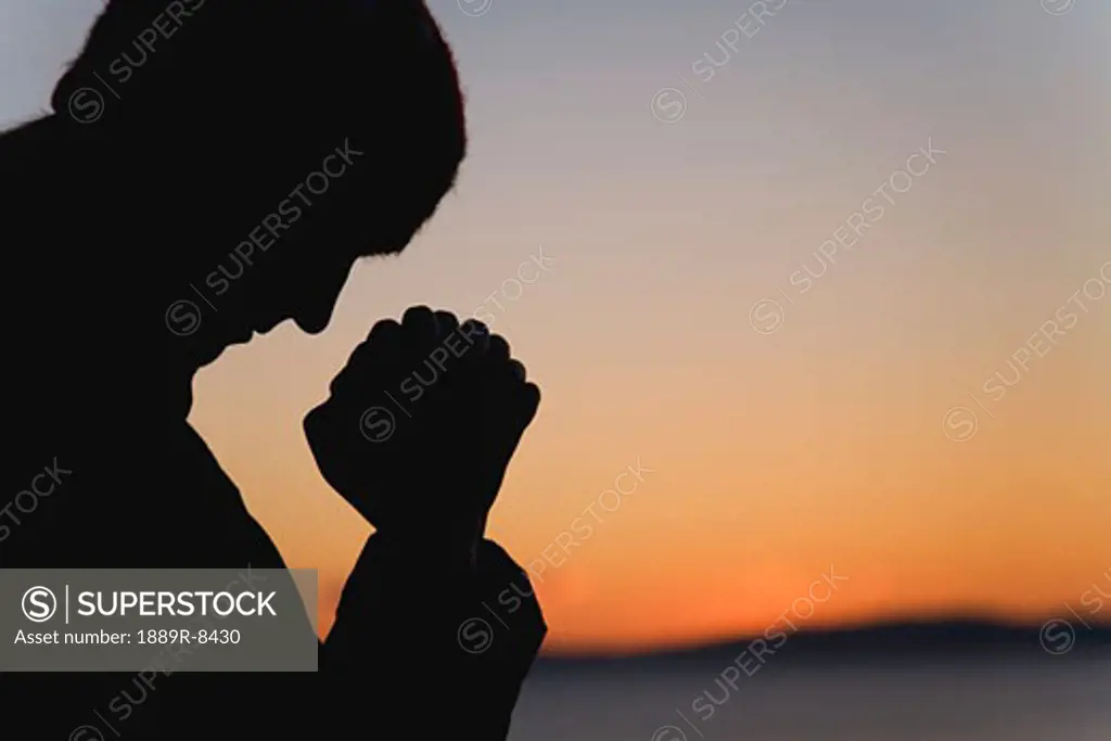 Silhouette of a man praying
